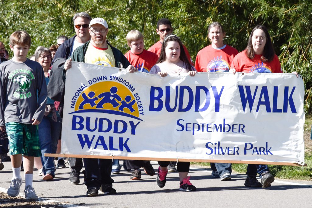 Volunteers and participants holding banner in annual MTDSA Buddy Walk